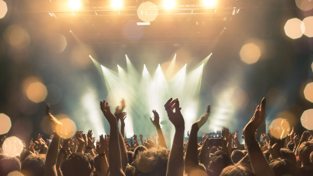 Festival-Stimmung mit tanzender Menschenmenge und bunten Lichtern auf der Bühne